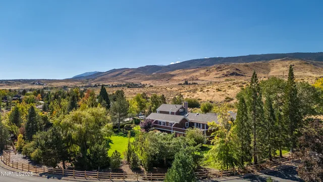 an aerial view of residential houses with outdoor space and trees