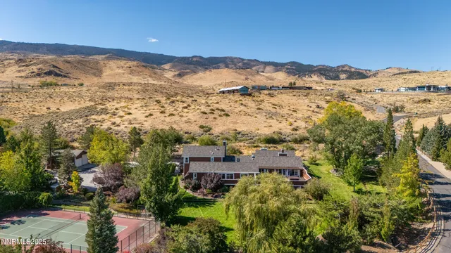 an aerial view of residential houses with outdoor space and trees