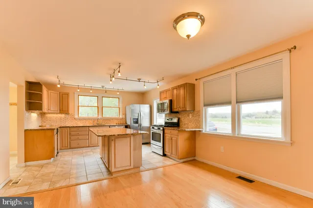 a large kitchen with lots of counter top space and stainless steel appliances