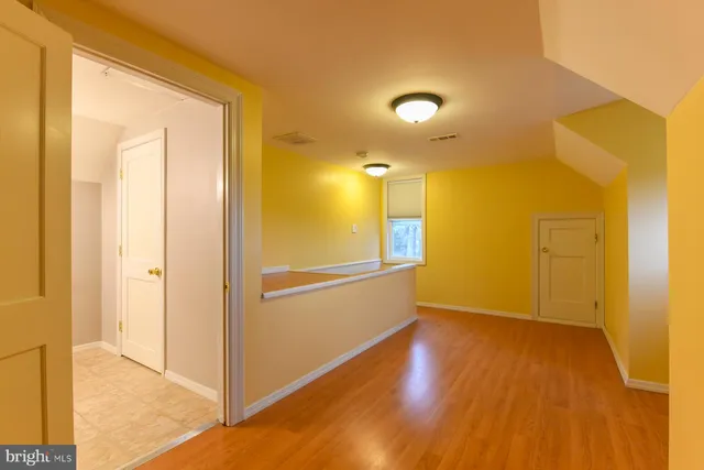 a view of empty room with wooden floor
