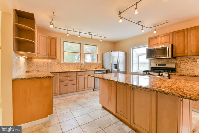 a kitchen with stainless steel appliances a sink window and cabinets