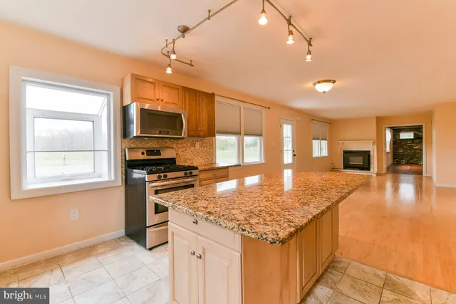 a kitchen with stainless steel appliances granite countertop a sink stove and cabinets