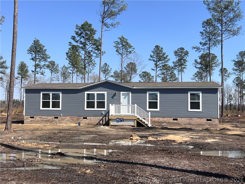 1452 Mercer Mill Road Lumberton, NC 28358 - Photo 1 of 17 a view of a house with a yard covered with snow in the background