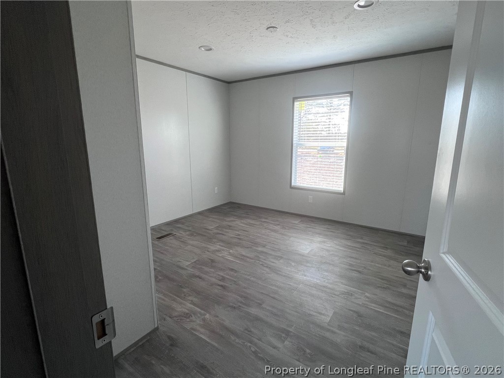 1452 Mercer Mill Road Lumberton, NC 28358 - Photo 12 of 19 an empty room with wooden floor and windows