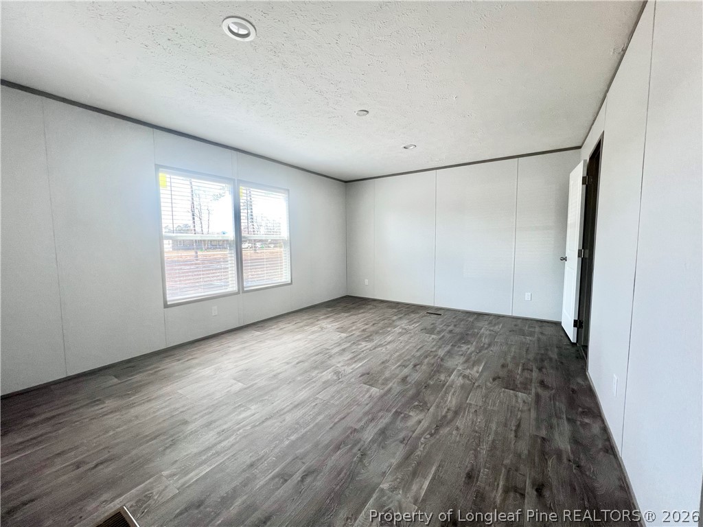 1452 Mercer Mill Road Lumberton, NC 28358 - Photo 12 of 17 an empty room with wooden floor and windows