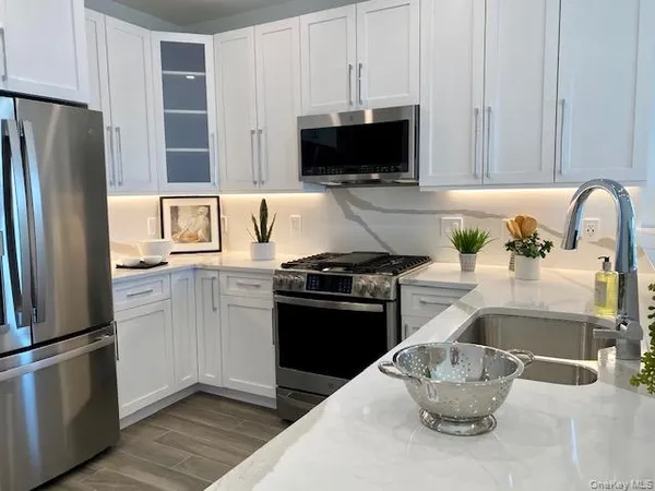 a kitchen with stainless steel appliances granite countertop a refrigerator and a sink