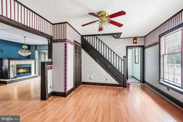 a view of an entryway with wooden floor door and a fireplace