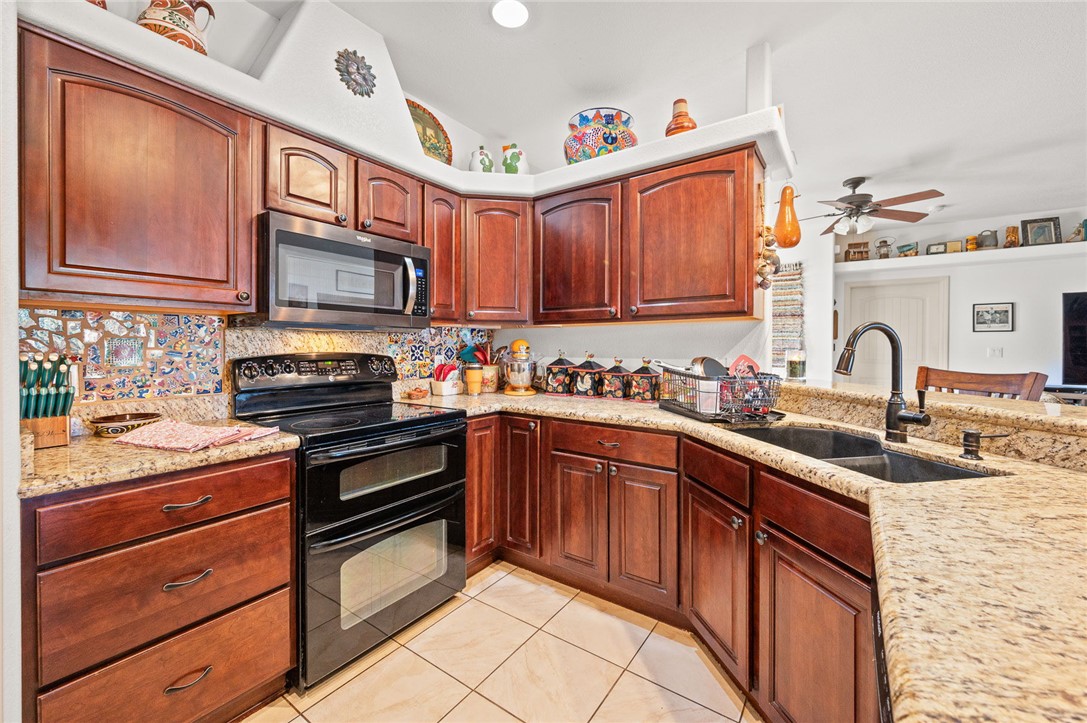 14105 Cactus Road Yucca, AZ 86438 - Photo 14 of 47 a kitchen with stainless steel appliances granite countertop a sink stove and cabinets