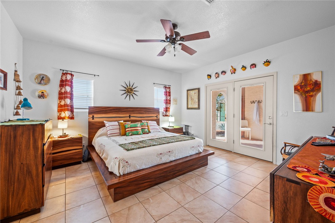 14105 Cactus Road Yucca, AZ 86438 - Photo 18 of 47 a bedroom with a bed and a chandelier