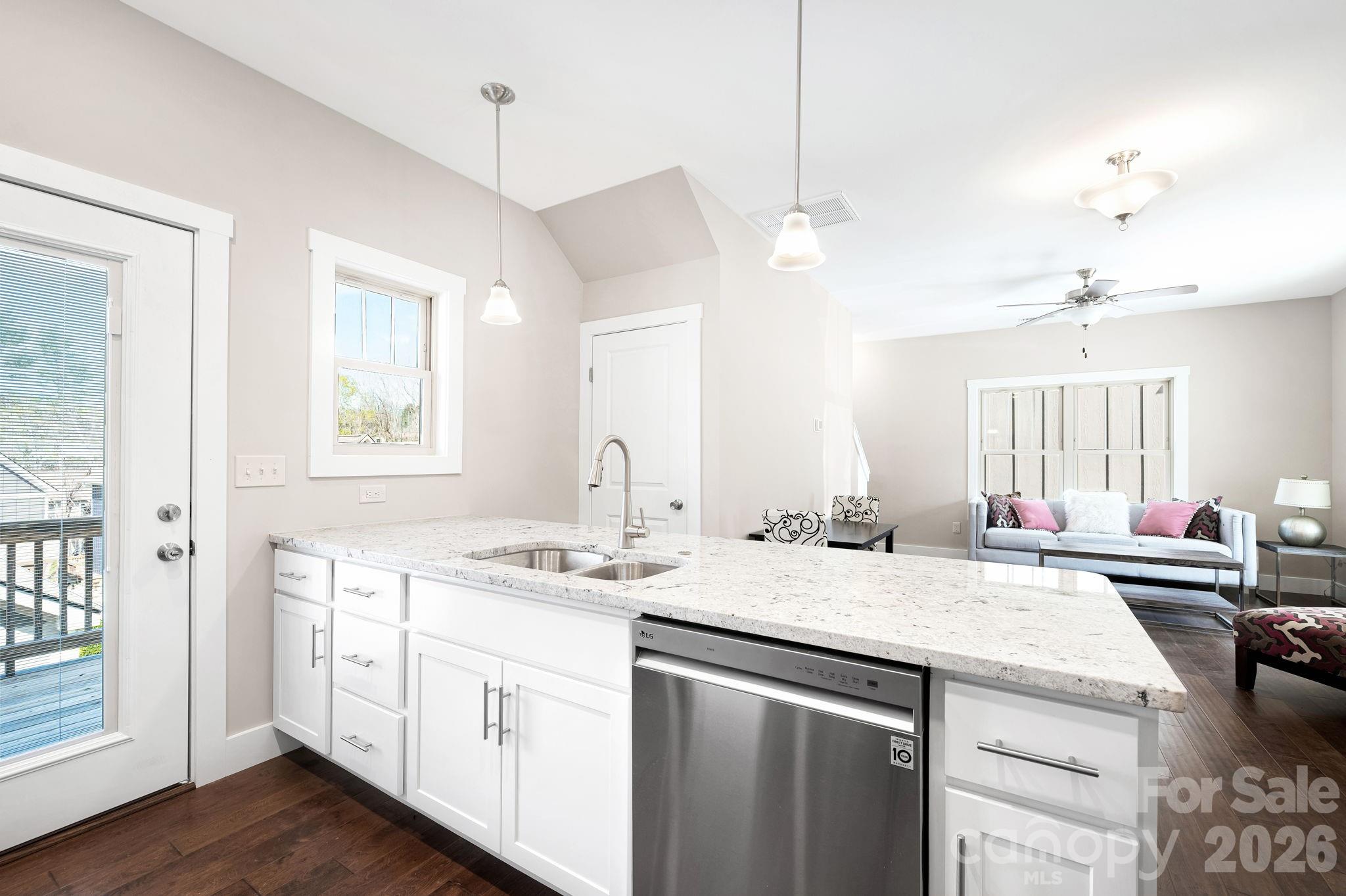 79 Wheeler Road Weaverville, NC 28787 - Photo 6 of 33 a kitchen with a sink dishwasher and white cabinets with wooden floor