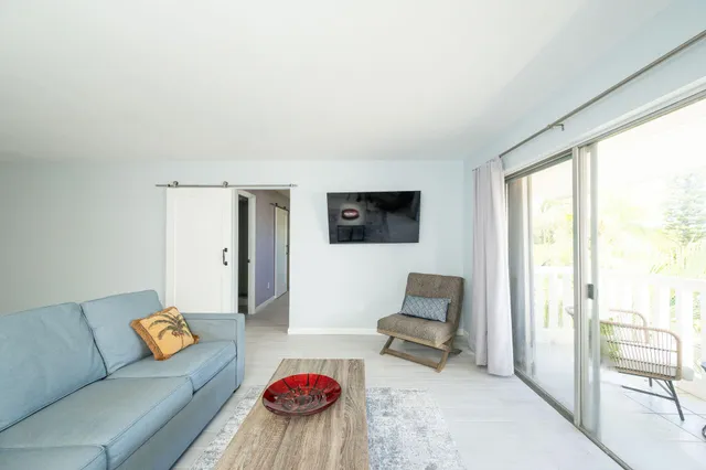 a living room with stainless steel appliances granite countertop furniture and a sink