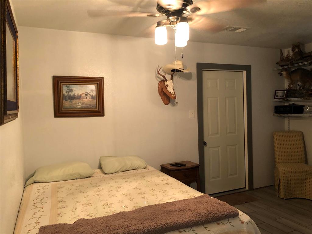 190 Private Road Groesbeck, TX 76642 - Photo 13 of 25 a bedroom with a bed and a chandelier