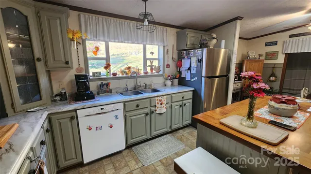 a kitchen with stainless steel appliances granite countertop a refrigerator a stove a sink dishwasher and a dining table with wooden floor