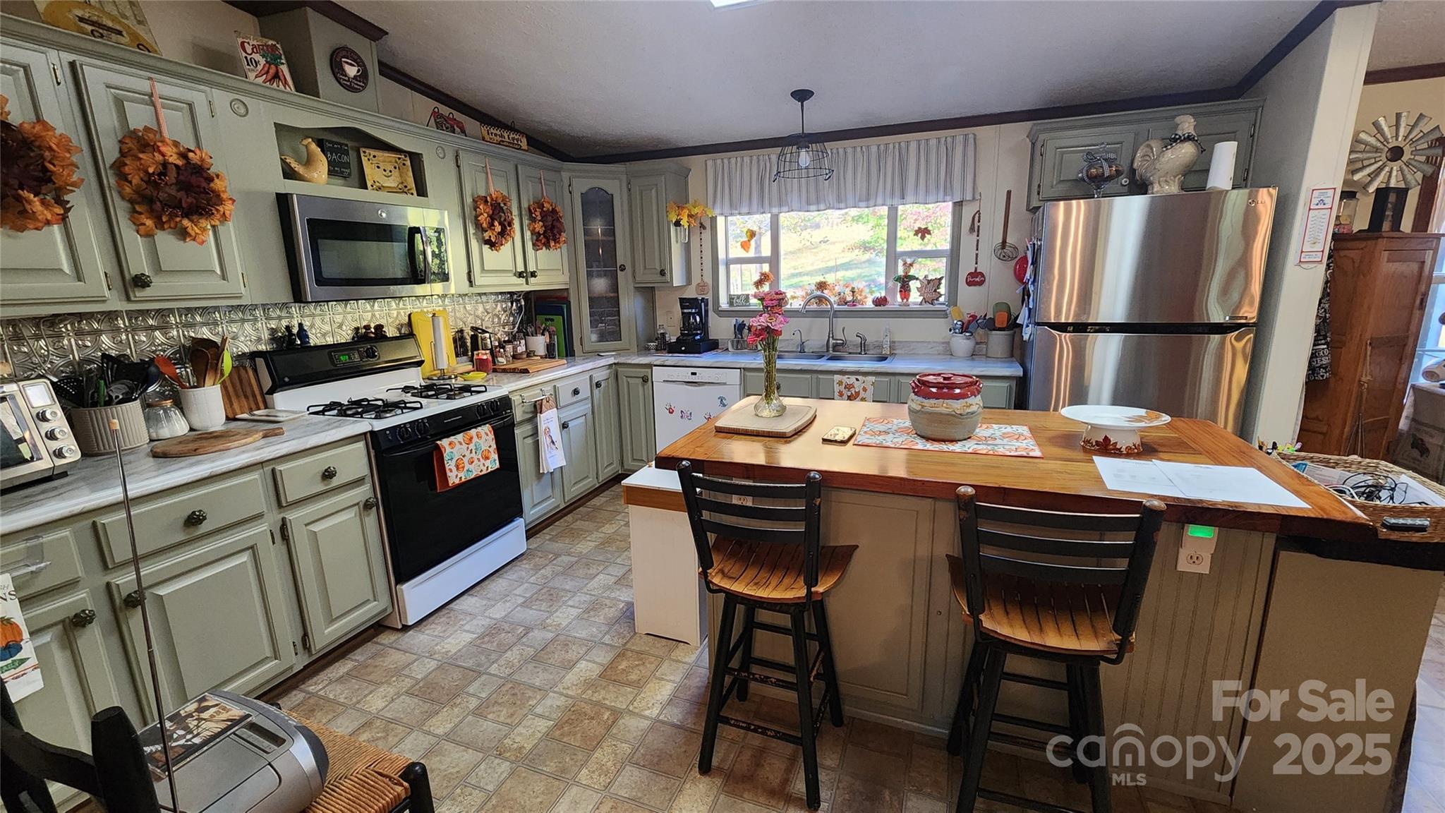 141 Hungry Creek Road Canton, NC 28716 - Photo 32 of 38 a kitchen with stainless steel appliances granite countertop a refrigerator a stove a sink dishwasher and a dining table with wooden floor