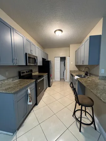 a kitchen with granite countertop wooden cabinets and stainless steel appliances