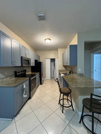 a kitchen with stainless steel appliances granite countertop a stove top oven a sink dishwasher and cabinets with wooden floor
