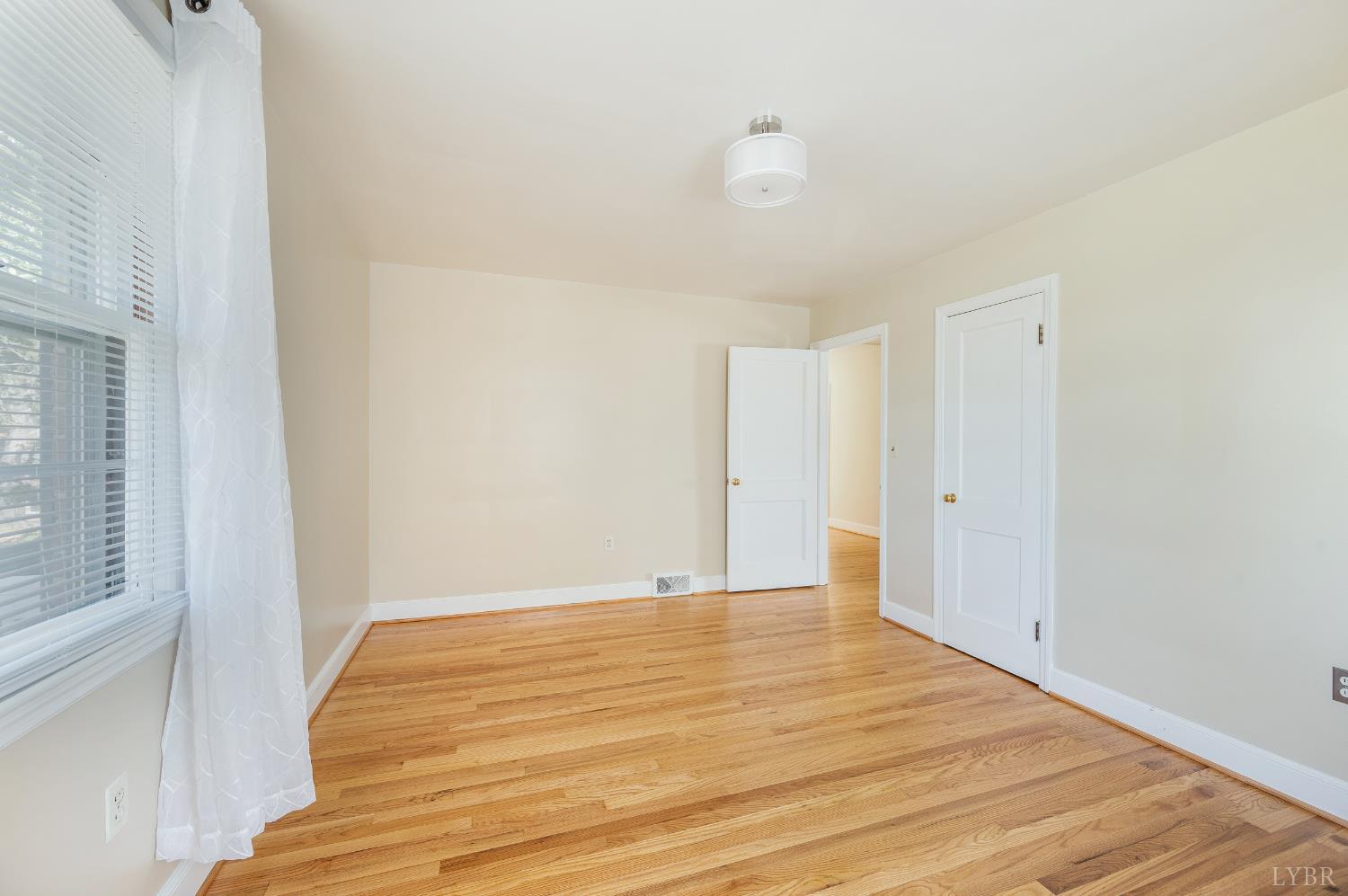 710 Riverside Drive Lynchburg, VA 24503 - Photo 9 of 53 a view of an empty room with wooden floor and a window