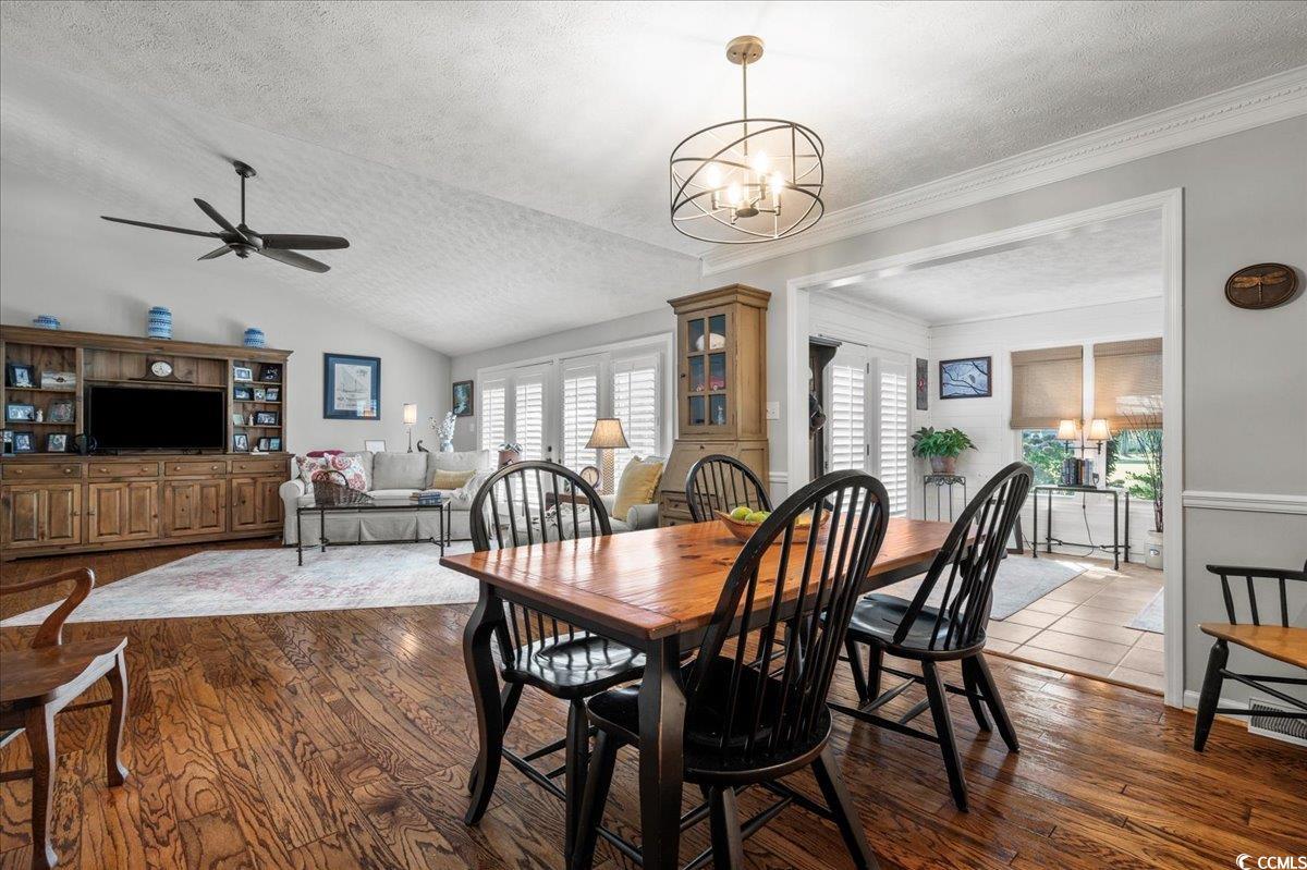 117 John Waites Court Georgetown, SC 29440 - Photo 12 of 40 Dining area with a textured ceiling, a chandelier, dark wood-style flooring, lofted ceiling, and ceiling fan