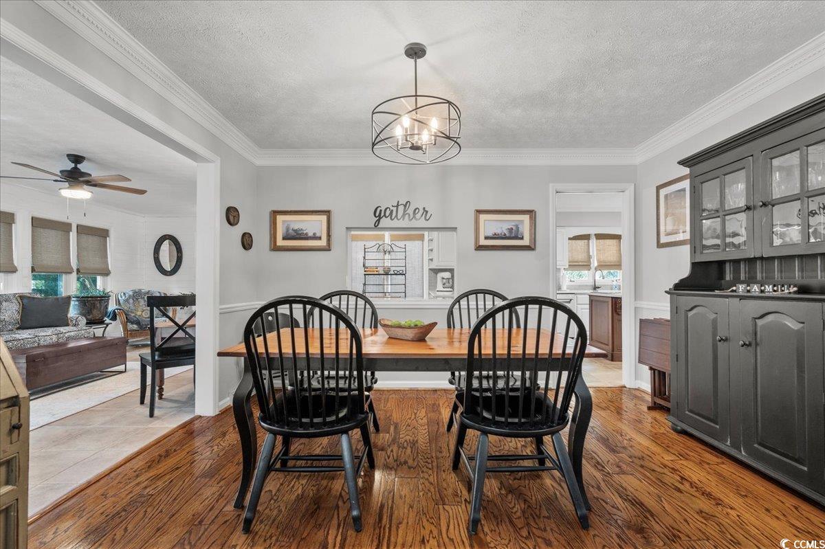 117 John Waites Court Georgetown, SC 29440 - Photo 13 of 40 Dining room featuring a textured ceiling, crown molding, a chandelier, dark wood finished floors, and ceiling fan