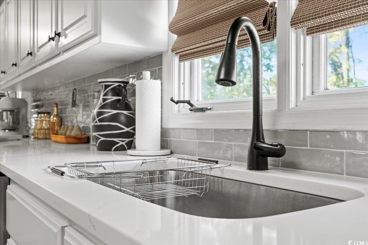 117 John Waites Court Georgetown, SC 29440 - Photo 14 of 40 Kitchen view of decorative backsplash, white cabinetry, and light stone countertops