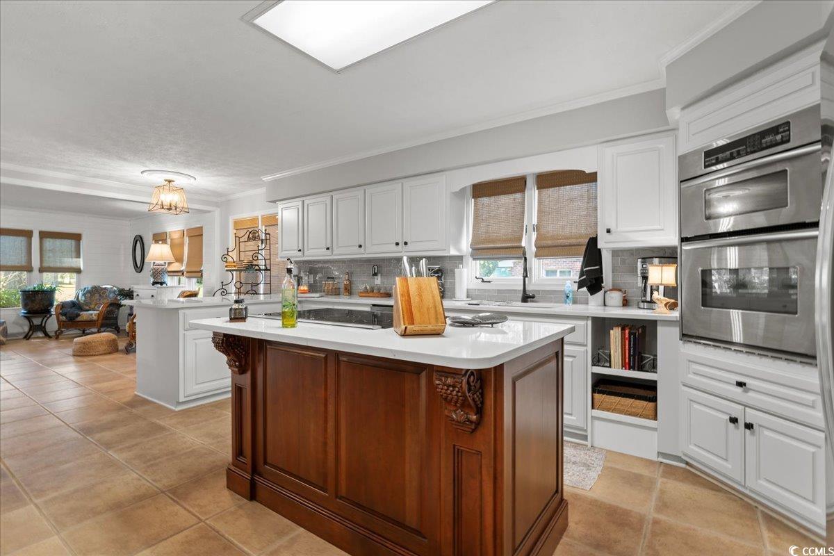 117 John Waites Court Georgetown, SC 29440 - Photo 18 of 40 Kitchen with white cabinetry, double oven, tasteful backsplash, crown molding, and healthy amount of natural light