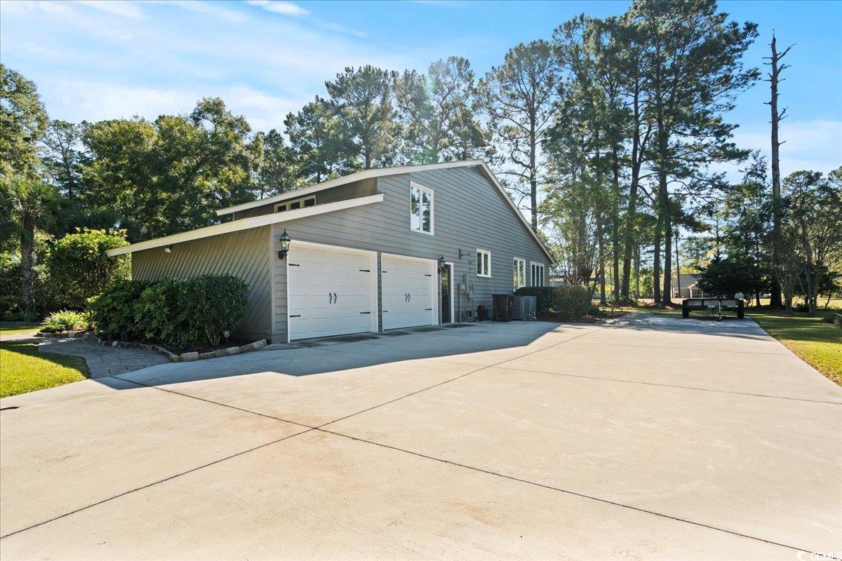 117 John Waites Court Georgetown, SC 29440 - Photo 37 of 40 View of side of property with a garage, driveway, and view of scattered trees