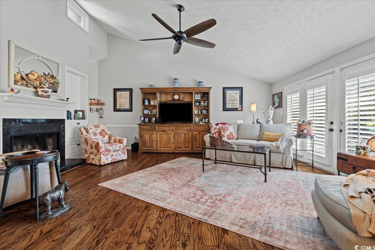 117 John Waites Court Georgetown, SC 29440 - Photo 7 of 40 Living room featuring lofted ceiling, a textured ceiling, dark wood finished floors, a high end fireplace, and a ceiling fan