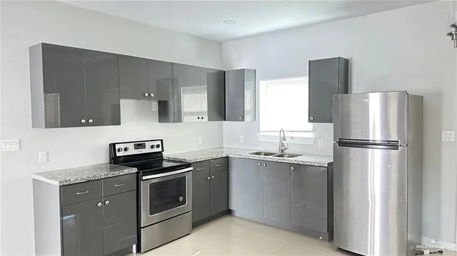 a kitchen with stainless steel appliances granite countertop a refrigerator sink and stove