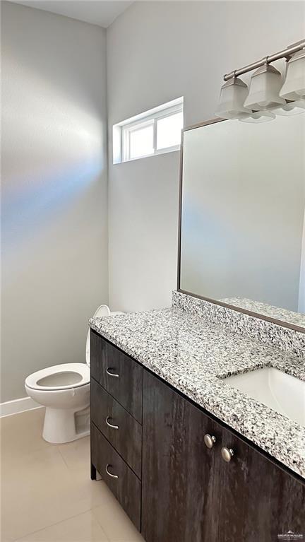 1908 Harrison Street, Unit 14 Weslaco, TX 78599 - Photo 8 of 10 a bathroom with a granite countertop sink a toilet and mirror