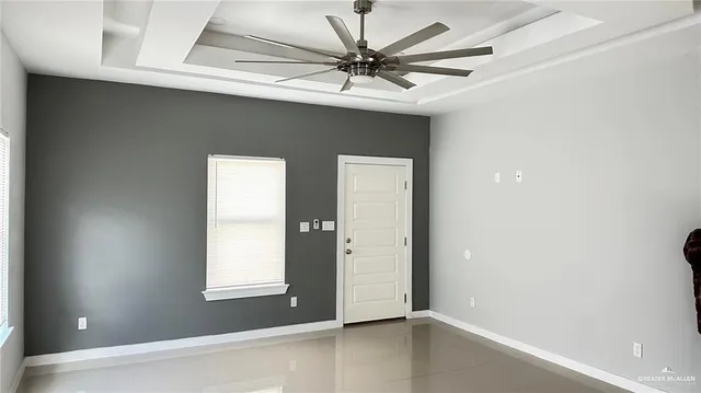 an empty room with a window and a ceiling fan