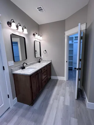 a bathroom with a double vanity sink and a mirror