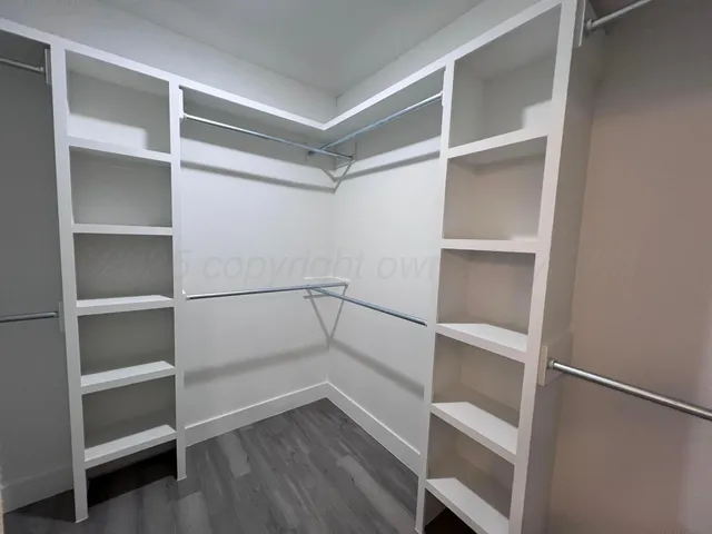 a view of walk in closet with empty racks