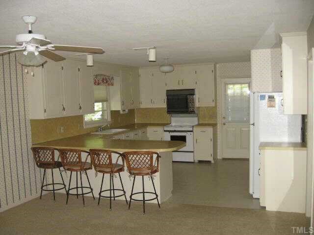 704 Torredge Road Durham, NC 27712 - Photo 5 of 7 a kitchen with a table chairs refrigerator and cabinets