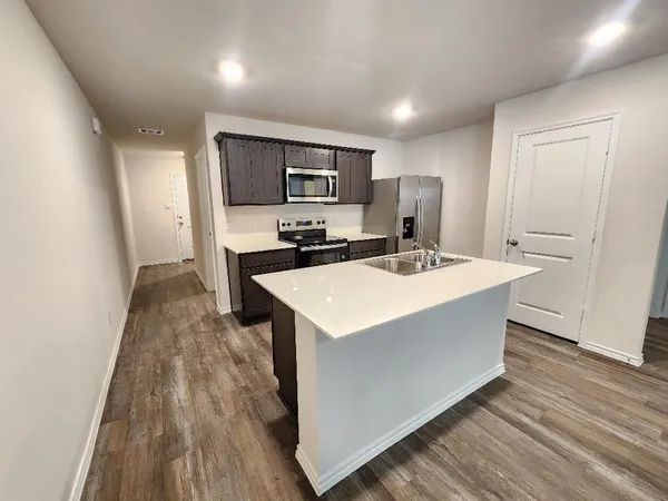 a kitchen with a sink a counter top space and cabinets
