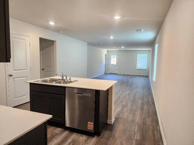 a kitchen with a sink and wooden floor