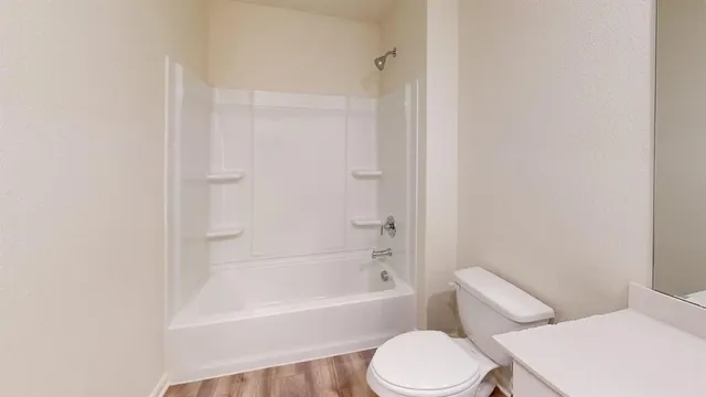 a white toilet and tub sitting next to a white cabinet