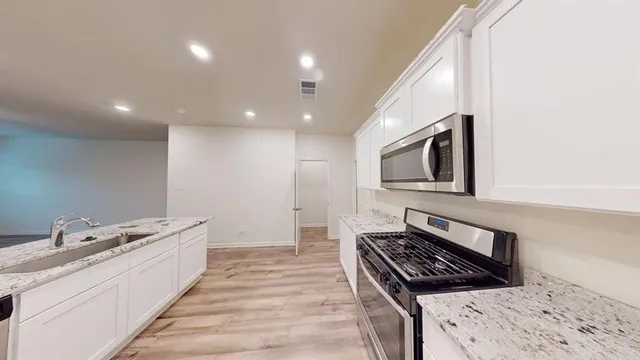 a kitchen with stainless steel appliances granite countertop a stove and a sink