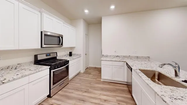 a kitchen that has a sink and a stove top oven