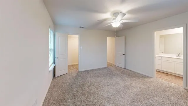 an empty room with closet and a chandelier fan