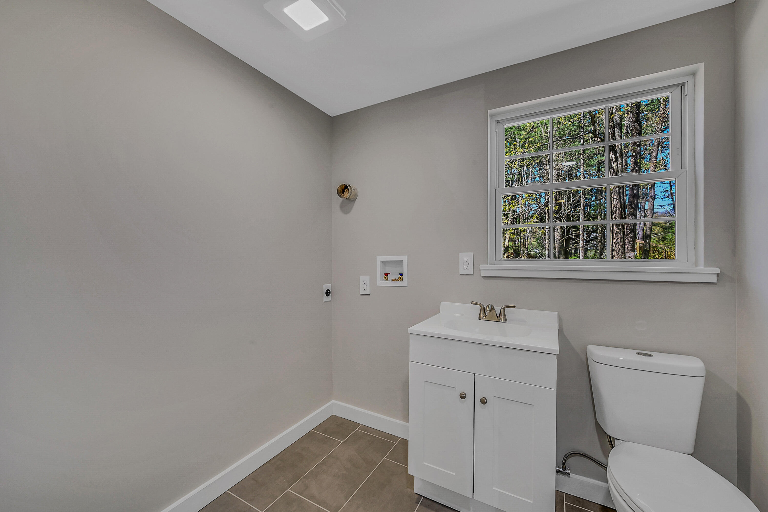 133 Neil Thompson Road Lackawaxen, PA 18425 - Photo 25 of 65 a bathroom with a toilet sink vanity and window