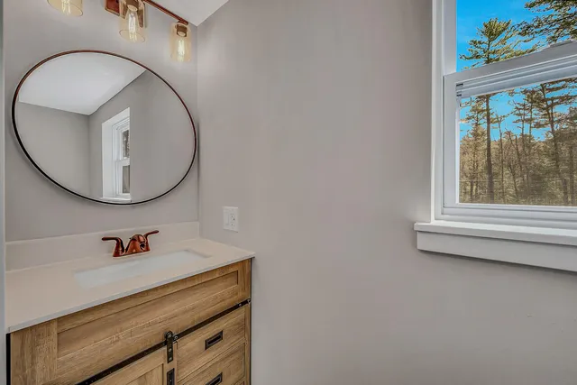 a bathroom with a sink mirror and toilet
