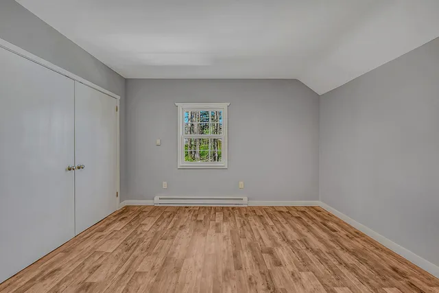 a view of a room with wooden floor and white walls