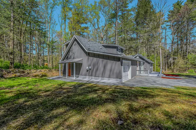 a view of a house with a yard and wooden fence