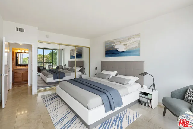 a bedroom with a bed and a large window