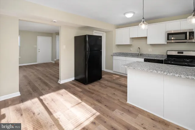 a kitchen with stainless steel appliances granite countertop a refrigerator and a stove top oven