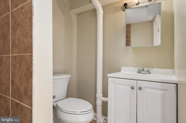 a bathroom with a toilet a sink and mirror