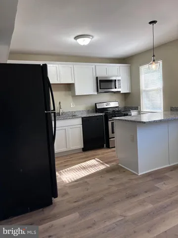 a kitchen with stainless steel appliances granite countertop a stove top oven a sink and a microwave