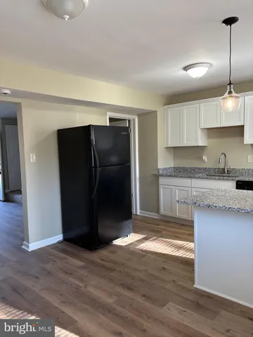 a kitchen with granite countertop a refrigerator and a sink