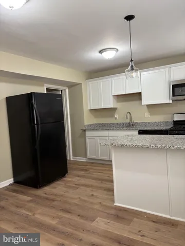 a kitchen with granite countertop a refrigerator and a sink