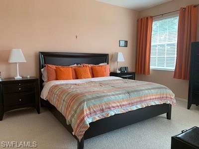 2021 Crestview Way, Unit 113 Naples, FL 34119 - Photo 13 of 24 a large bed sitting in a bedroom next to a window